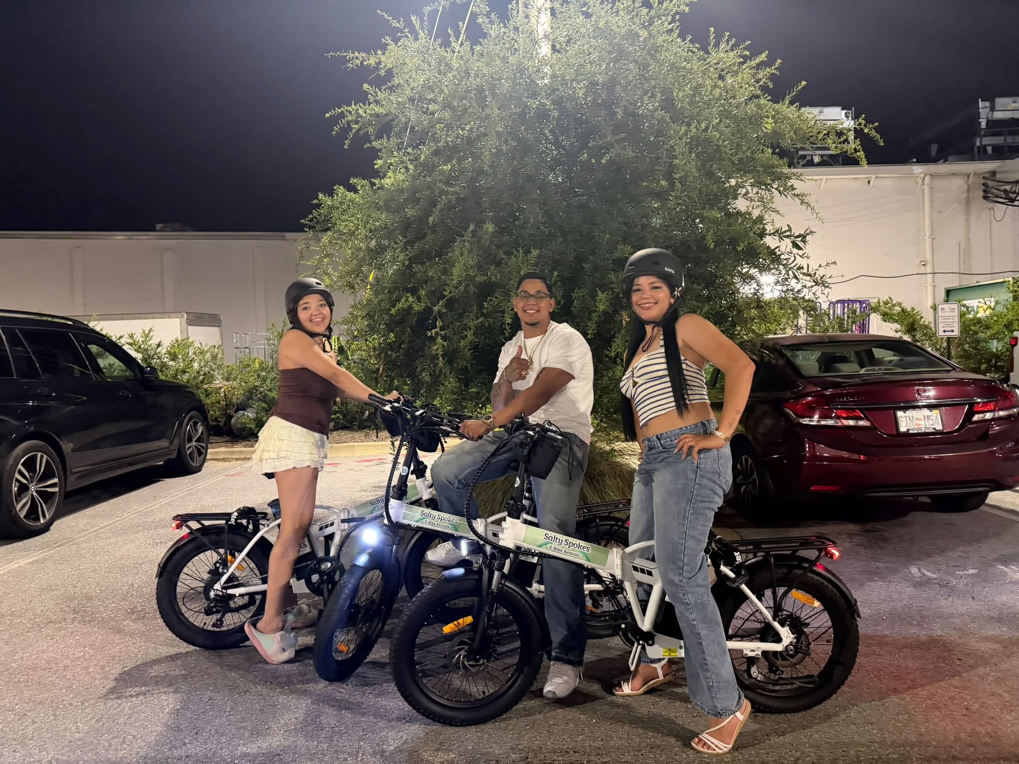 Three friends enjoying a nighttime Salty Spokes e-bike ride